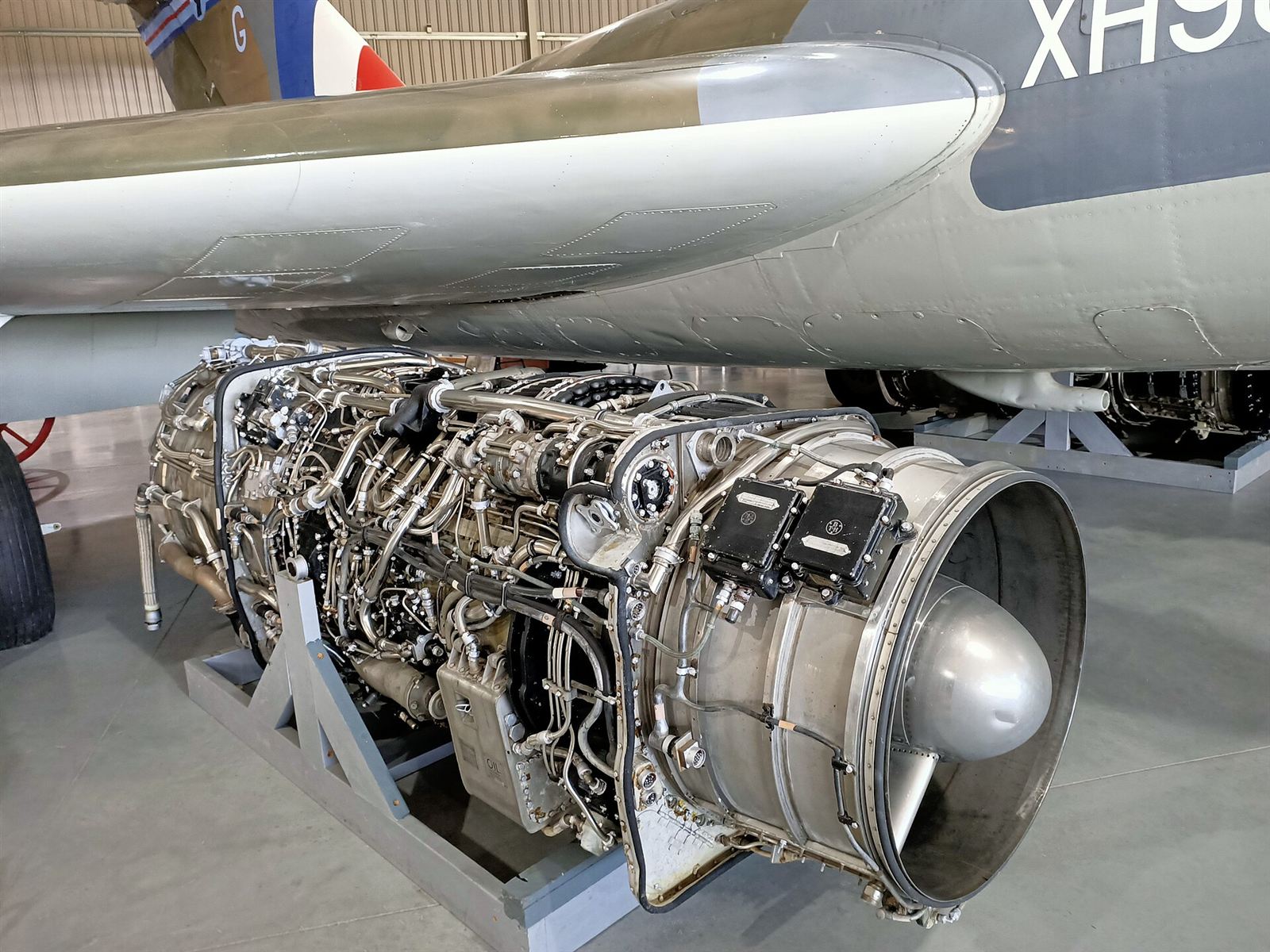 Jet engine on a display stand under an aircraft wing
