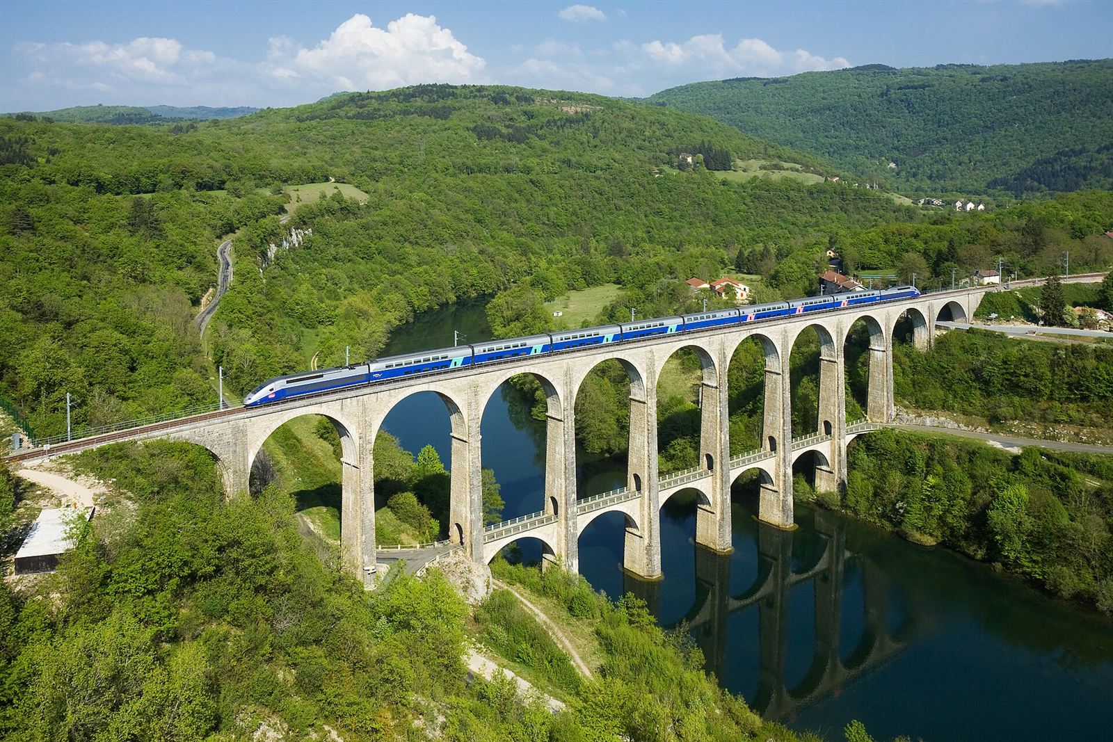 High-speed train crossing a stone viaduct